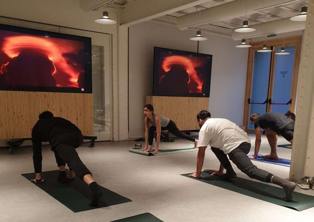 Grupo de personas practicando yoga en el salón de una empresa